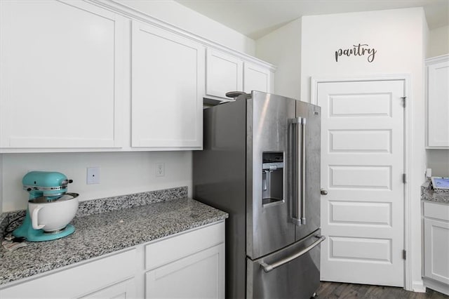 kitchen featuring light stone countertops, white cabinetry, and high end fridge