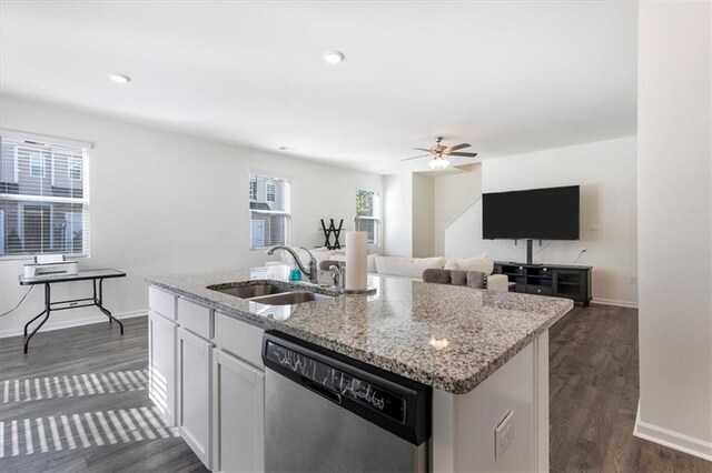 kitchen with white cabinets, dishwasher, an island with sink, sink, and light stone counters