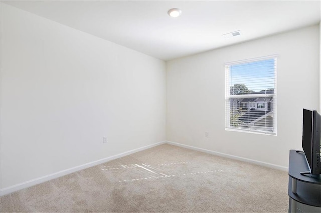 spare room featuring light colored carpet