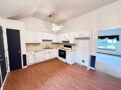 60 Parkman Trl, Covington, GA 30016 - kitchen with white appliances, light countertops, white cabinetry, a sink, and high vaulted ceiling