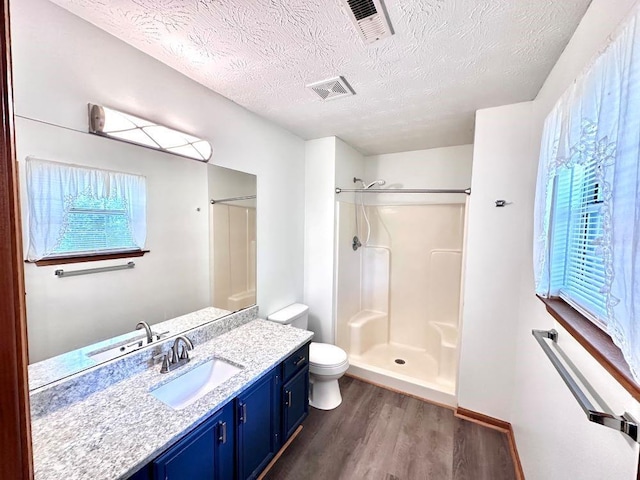 60 Parkman Trl, Covington, GA 30016 - full bathroom featuring toilet, wood finished floors, a textured ceiling, a walk in shower, and vanity