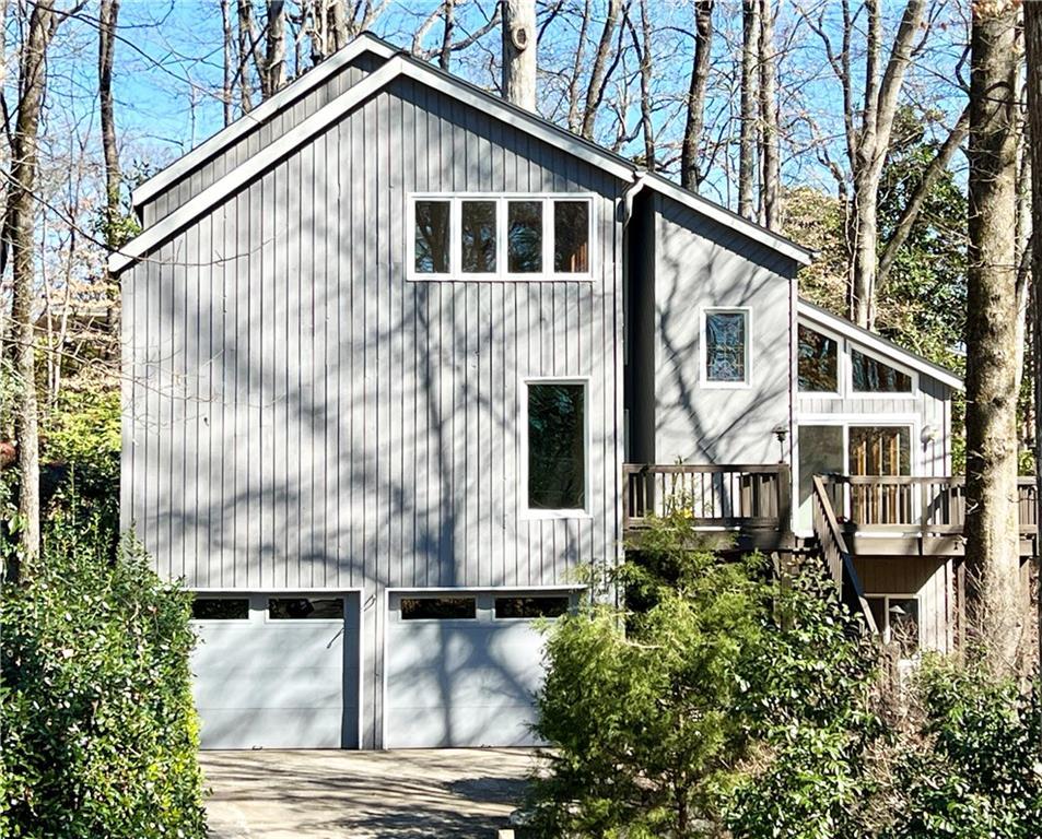 view of side of home with a garage, driveway, and stairway