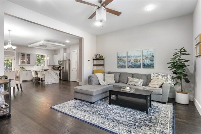 living room featuring dark hardwood / wood-style floors and ceiling fan with notable chandelier