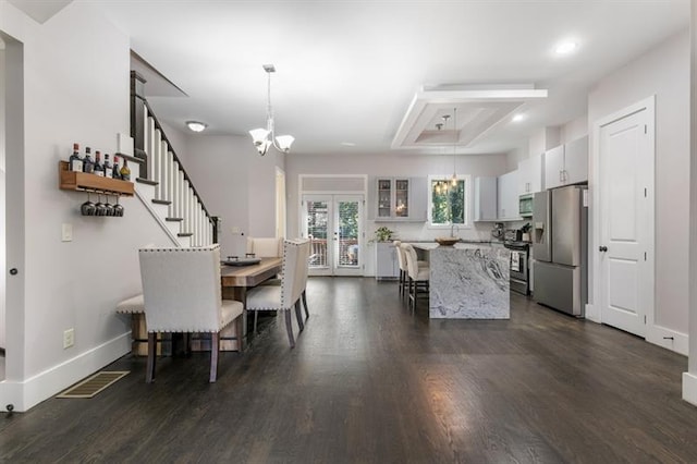 dining area featuring dark hardwood / wood-style flooring, french doors, and a chandelier