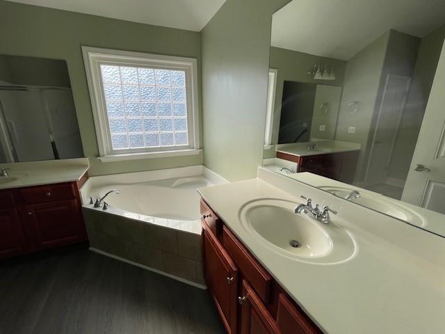 bathroom with wood-type flooring, vanity, and separate shower and tub