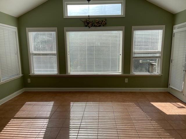 unfurnished sunroom with vaulted ceiling, a wealth of natural light, and a notable chandelier