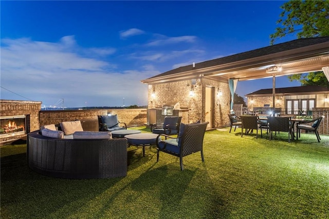 view of yard with french doors, an outdoor living space with a fireplace, outdoor dining area, and a patio area