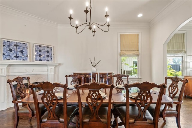dining area featuring an inviting chandelier, arched walkways, crown molding, and dark wood finished floors