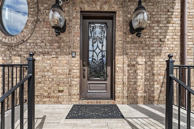 view of exterior entry featuring brick siding