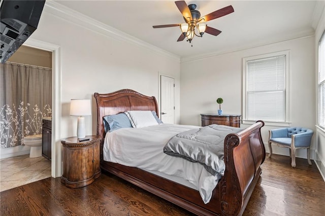 bedroom with crown molding, connected bathroom, baseboards, and wood finished floors