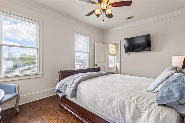 bedroom with crown molding, visible vents, multiple windows, and wood finished floors