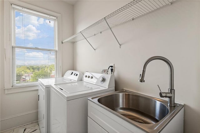 laundry room with laundry area, a sink, baseboards, and washing machine and dryer