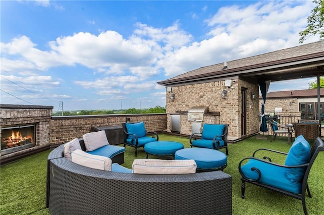view of patio with an outdoor kitchen, an outdoor living space with a fireplace, and area for grilling