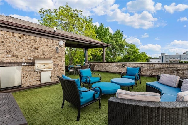 view of patio / terrace featuring grilling area, an outdoor kitchen, fence, and an outdoor hangout area