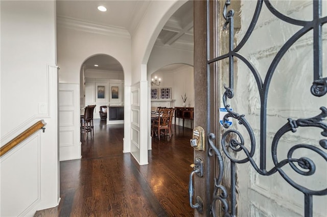 entrance foyer with a decorative wall, arched walkways, french doors, ornamental molding, and coffered ceiling