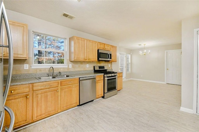 kitchen with sink, light hardwood / wood-style flooring, appliances with stainless steel finishes, decorative light fixtures, and light brown cabinets