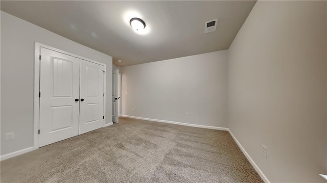 unfurnished bedroom with carpet, a closet, visible vents, and baseboards