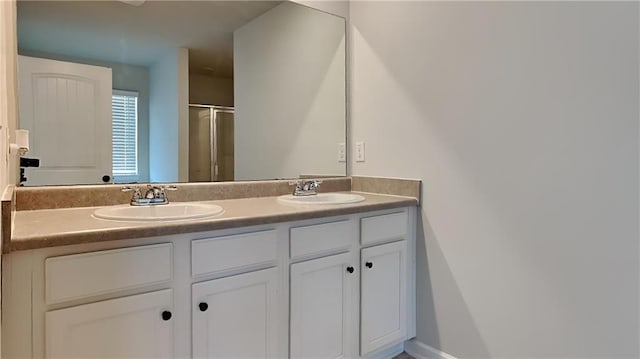 full bath with double vanity, a stall shower, and a sink