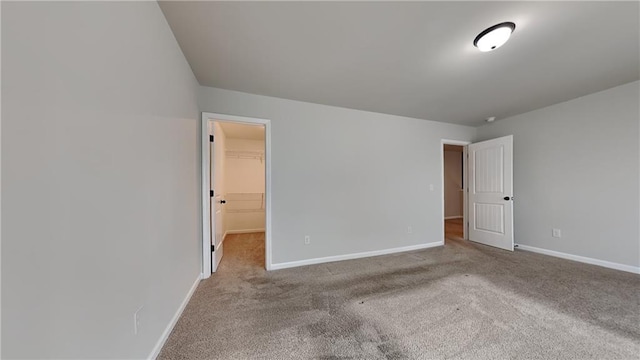 unfurnished room with carpet flooring and baseboards