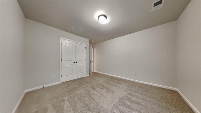 unfurnished room with carpet flooring, visible vents, and baseboards