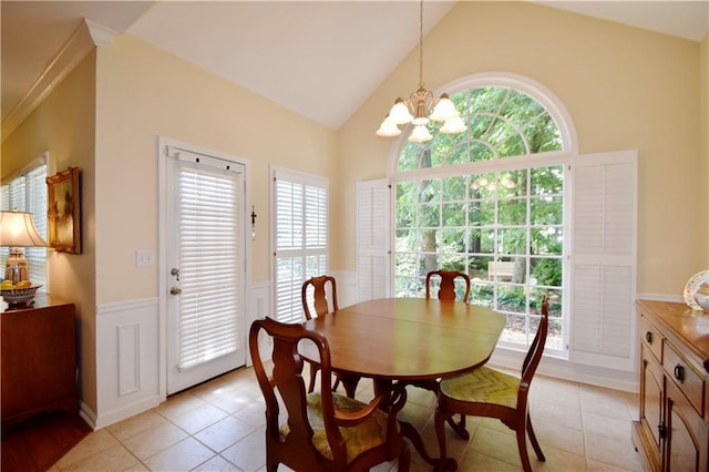 340 Channings Lake Dr, Lawrenceville, GA 30043 - dining area with wainscoting, a chandelier, lofted ceiling, light tile patterned flooring, and healthy amount of natural light