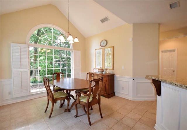 340 Channings Lake Dr, Lawrenceville, GA 30043 - dining area with wainscoting, a decorative wall, a chandelier, light tile patterned floors, and high vaulted ceiling