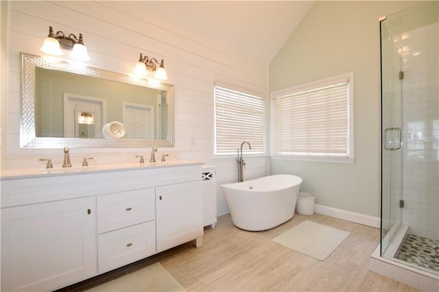 340 Channings Lake Dr, Lawrenceville, GA 30043 - full bathroom featuring vaulted ceiling, a shower stall, double vanity, wood finished floors, and a freestanding tub