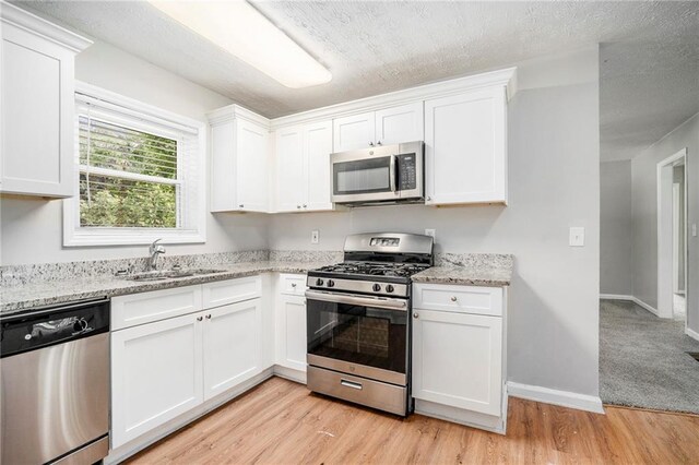 2623 Rex Ave SW, Atlanta, GA 30331 - kitchen featuring white cabinetry, stainless steel appliances, light wood finished floors, and a sink