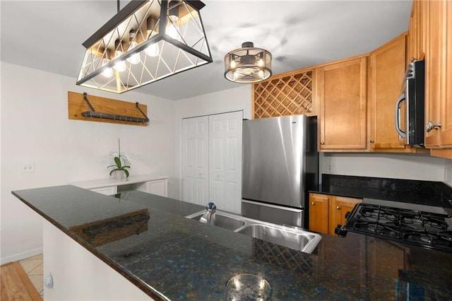 kitchen featuring stainless steel appliances, sink, pendant lighting, and kitchen peninsula