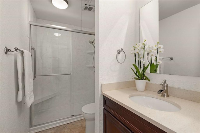 bathroom with vanity, tile patterned floors, toilet, and walk in shower