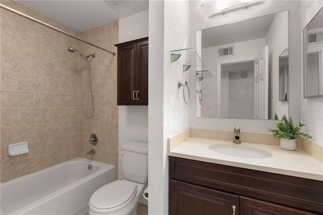 full bathroom featuring vanity, tiled shower / bath combo, and toilet