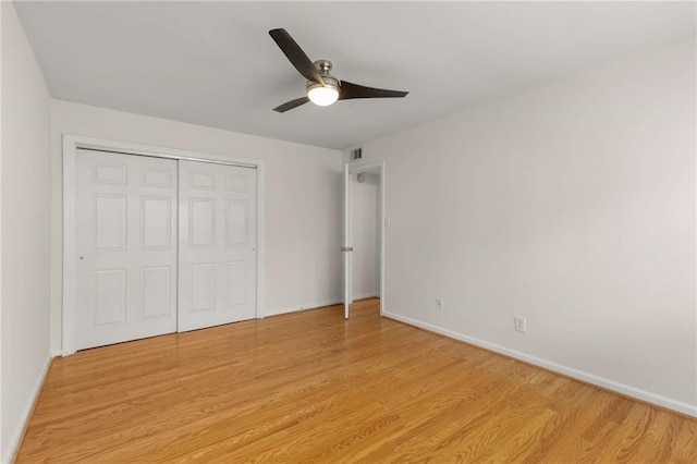 unfurnished bedroom with ceiling fan, a closet, and light wood-type flooring