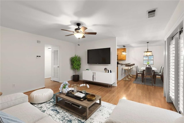 living room with ceiling fan and light hardwood / wood-style floors