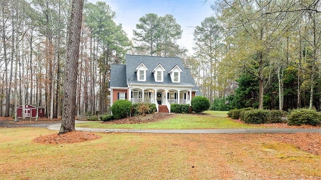 new england style home featuring a front lawn and covered porch