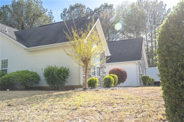 view of home's exterior featuring a garage and a yard