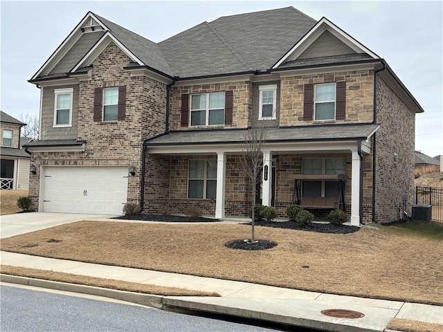 3566 Andover Way, Buford, GA 30519 - craftsman house featuring an attached garage, driveway, a porch, brick siding, and stone siding