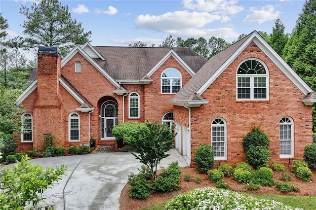 119 Kennemer Ct, Duluth, GA 30097 - traditional home with brick siding, a chimney, concrete driveway, and roof with shingles