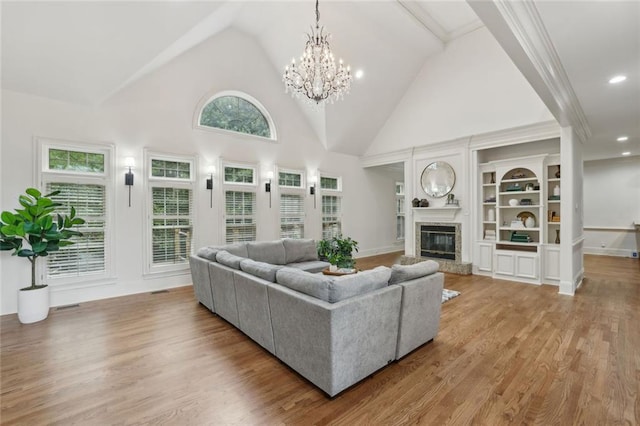 119 Kennemer Ct, Duluth, GA 30097 - living room with a chandelier, a glass covered fireplace, light wood-style floors, built in shelves, and recessed lighting