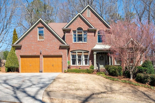 view of front of house with a garage, brick siding, and driveway