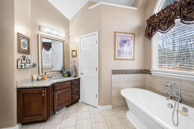 full bath featuring vanity, tile patterned flooring, and a freestanding bath