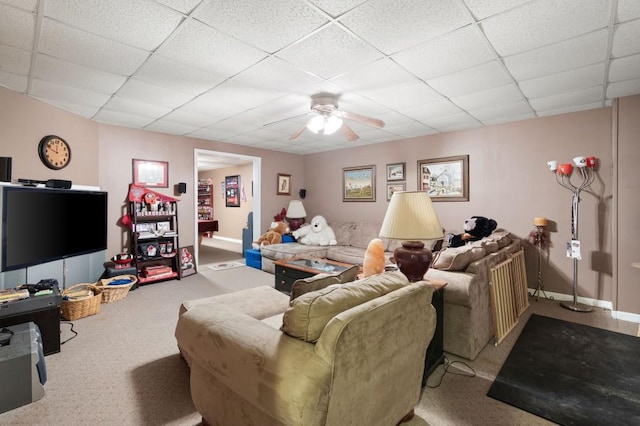 carpeted living area featuring a paneled ceiling, baseboards, and ceiling fan