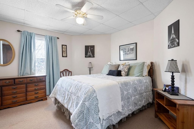 bedroom featuring a drop ceiling, ceiling fan, and carpet flooring