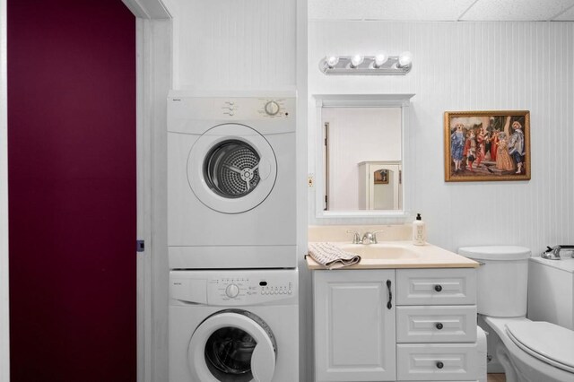 laundry room featuring stacked washer / dryer, laundry area, and a sink