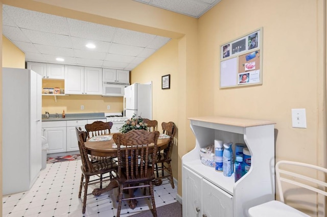 dining space featuring recessed lighting, a drop ceiling, and light floors