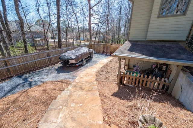 view of yard featuring driveway and fence