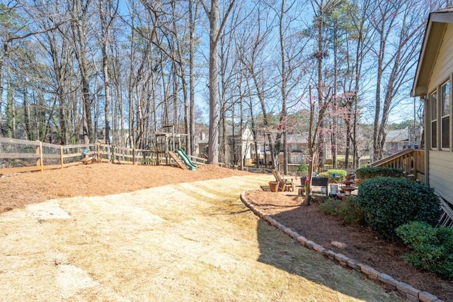 view of yard featuring playground community and fence