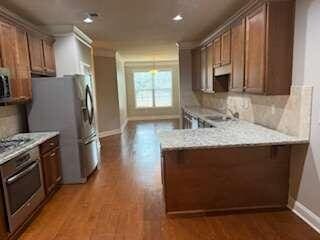 kitchen featuring stainless steel appliances, decorative backsplash, and hardwood / wood-style floors