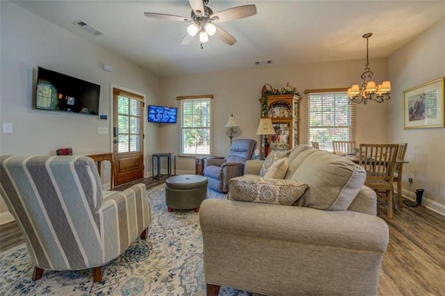 living room with hardwood / wood-style floors and ceiling fan with notable chandelier