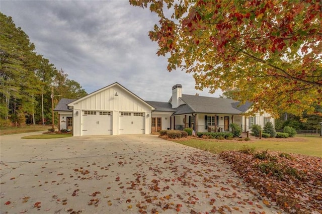 view of front of property with a front yard, a porch, and a garage