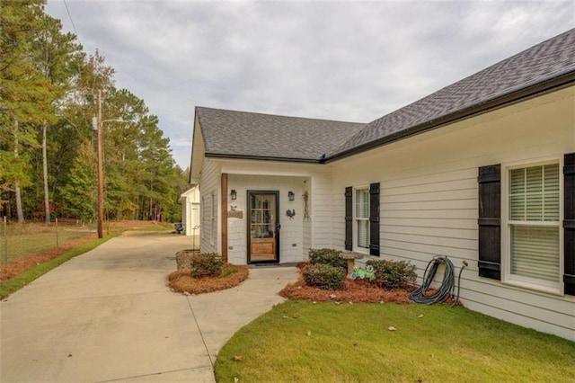 view of exterior entry with a lawn